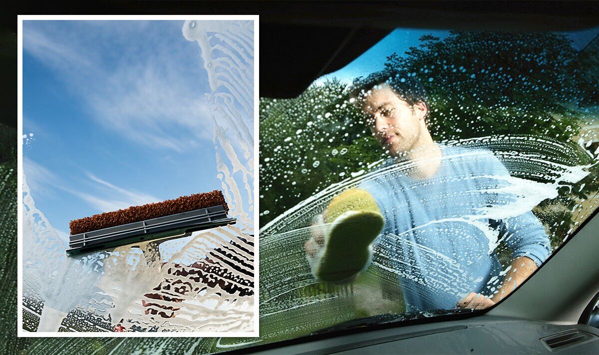 Man cleaning car windshield with sponge, comparing car spa and car valeting services