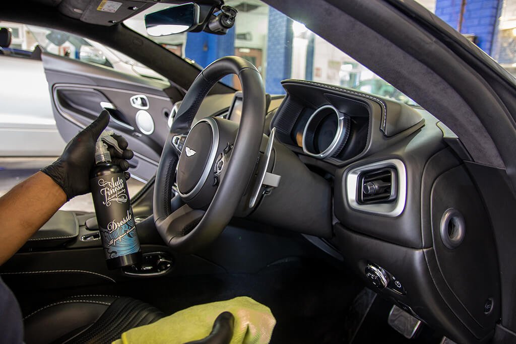 Expert performing car valet service on a luxury vehicle's interior