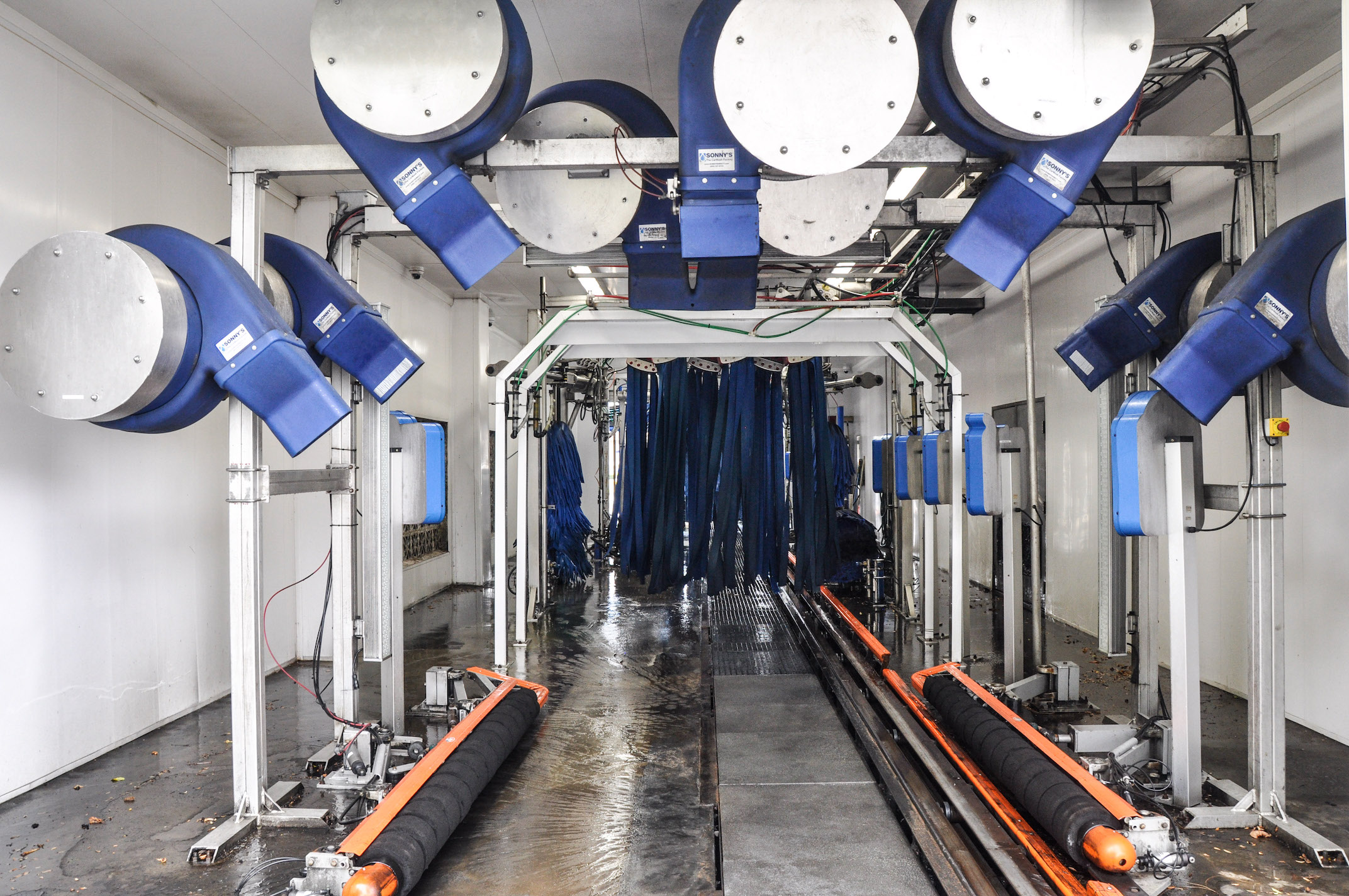 Interior view of a drive thru car wash facility, showcasing automated cleaning equipment and machinery.