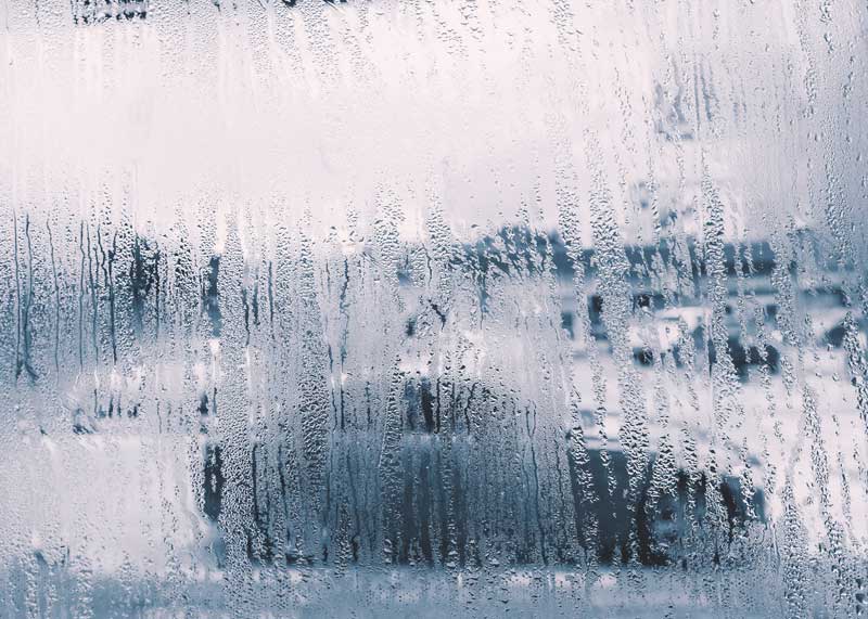 Steamed-up car window with water droplets obscuring the view