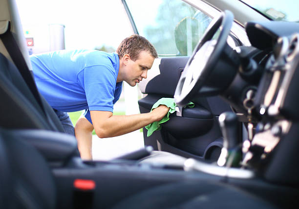 Man cleaning the interior of a car as part of a mobile car valeting service