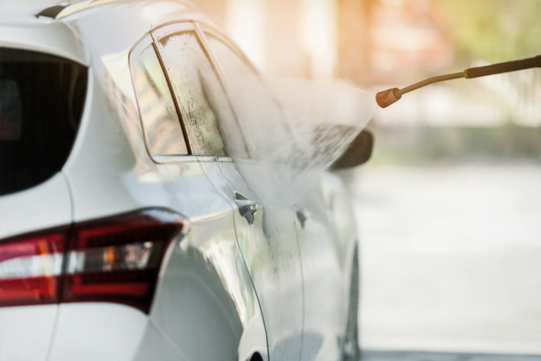 Car being washed with a high-pressure water jet