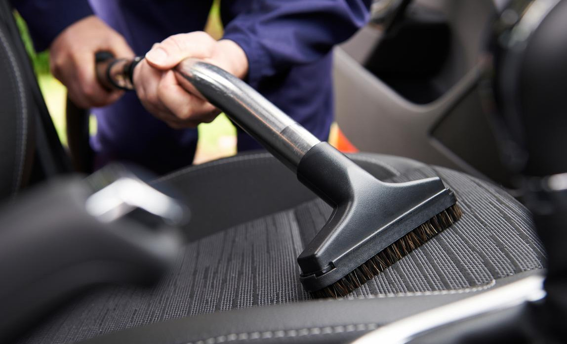 Car interior cleaning with a vacuum cleaner on fabric seats