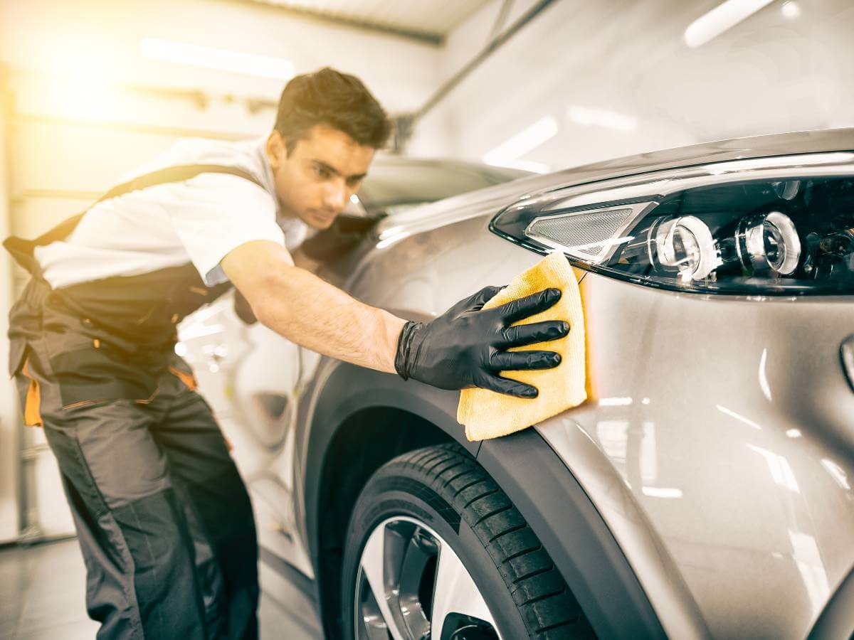 Detailing professional performing a full valet service on a car