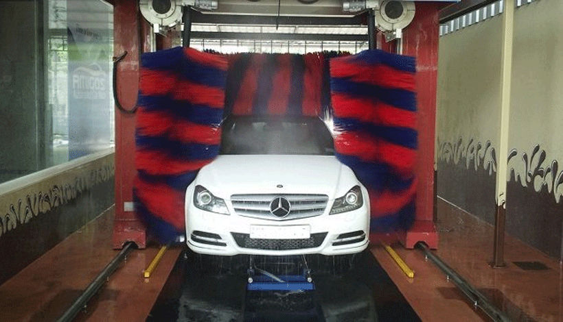 A white car getting a high-quality car wash at a petrol station, highlighting the convenience and efficiency of the service.