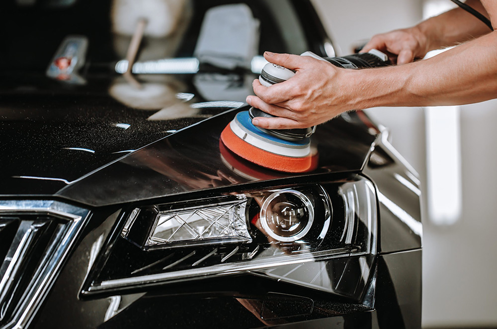 Close-up of a car being polished with a buffer for a perfect showroom finish