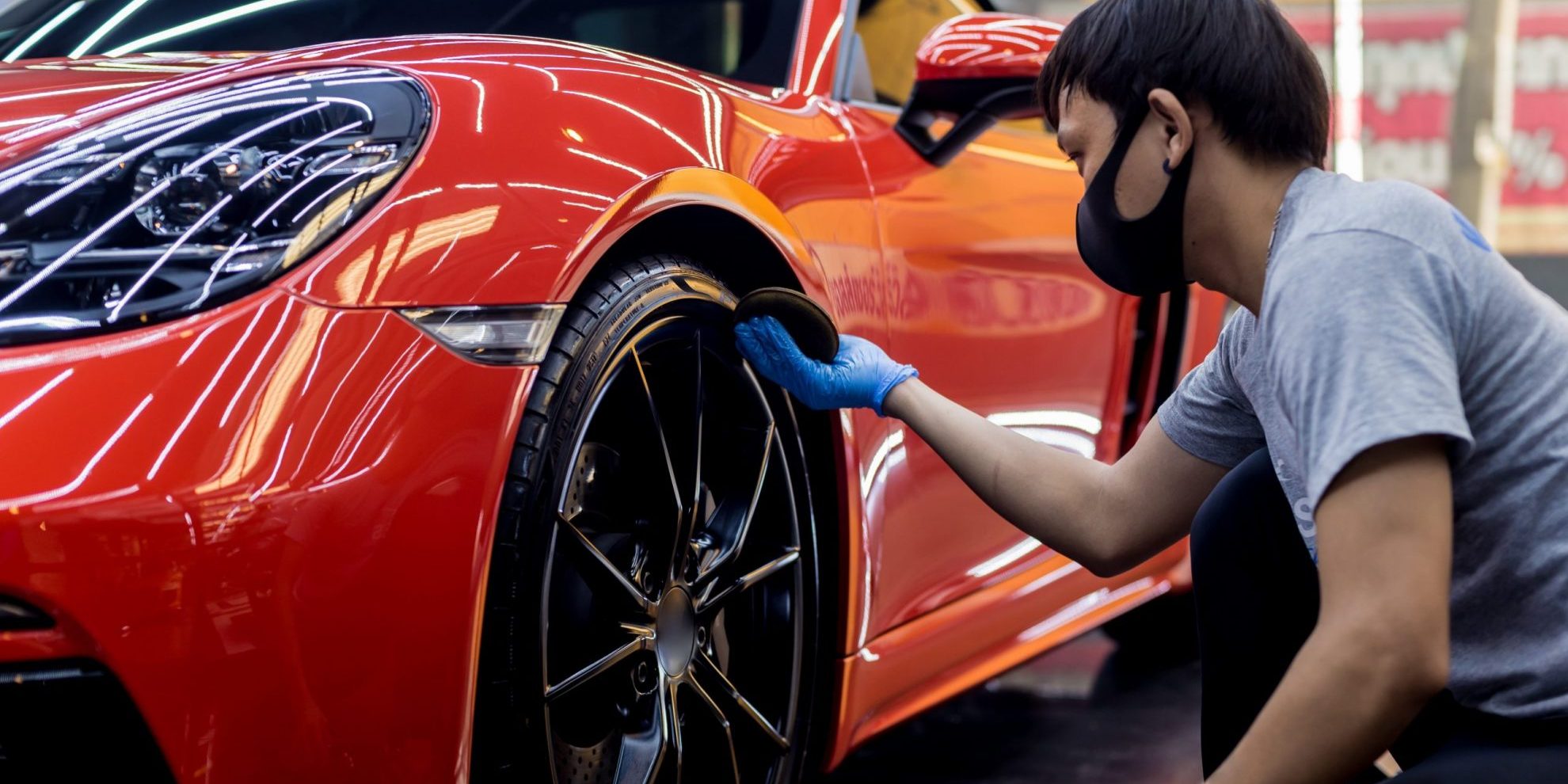 Professional mobile car wash service cleaning a red luxury car, ideal for busy remote workers in the UK.