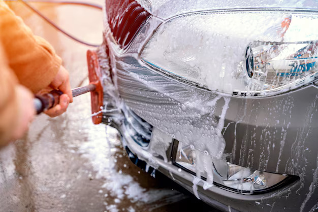 Close-up of a car being washed with soap at a self-autowash station